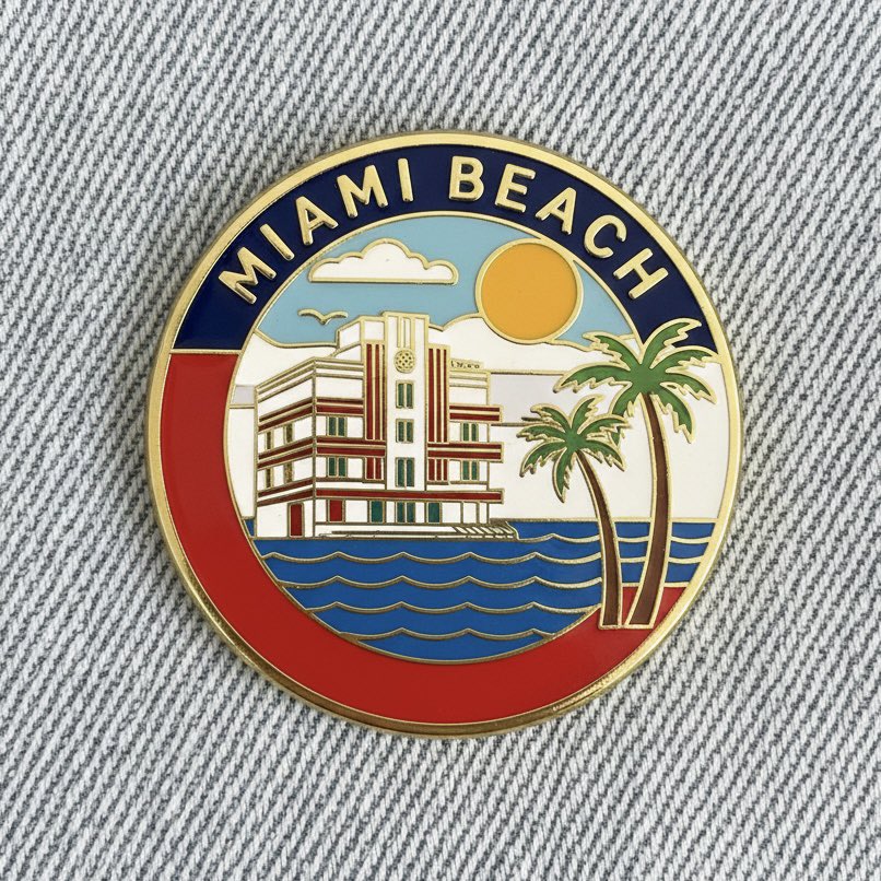 Close up photo of a collectible enamel pin of [CITY], gold pl...